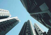 올해 ‘과세표준상한제’ 첫 시행…주택 재산세 부담 완화 looking up at tall buildings in a city