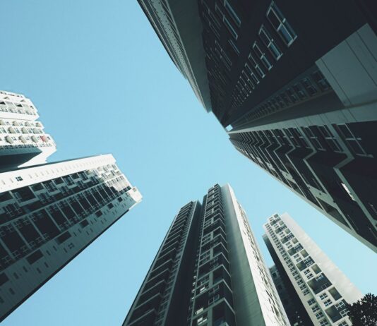 올해 ‘과세표준상한제’ 첫 시행…주택 재산세 부담 완화 looking up at tall buildings in a city