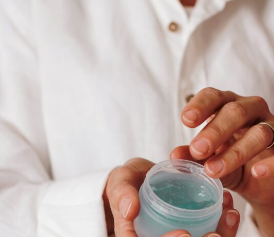 여름철 야외 활동 후 피부 관리법 person holding blue plastic container