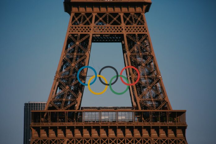 Photo by Bo Zhang The eiffel tower with the olympic rings in front of it