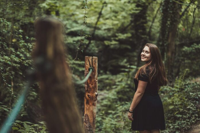 Photo by Daniel Dvorský woman standing beside post
