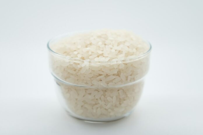 Photo by Mehmet Keskin a glass bowl filled with rice on top of a white table