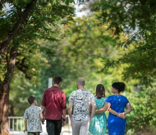 건강한 부모와 자녀의 관계 만들기 man in red t-shirt and gray pants holding hands with boy in blue t-shirt