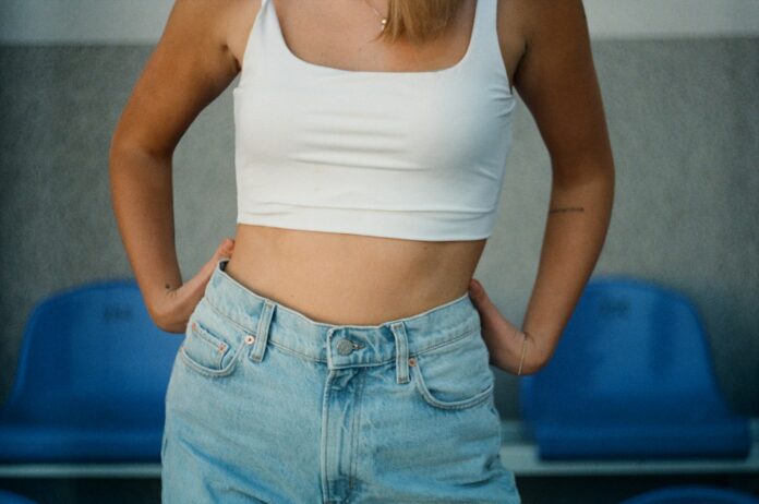 Photo by Eugene Chystiakov woman in white tank top and blue denim jeans