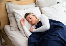 건강을 지키며 하는 다이어트 a woman sleeping on a bed with a blue blanket