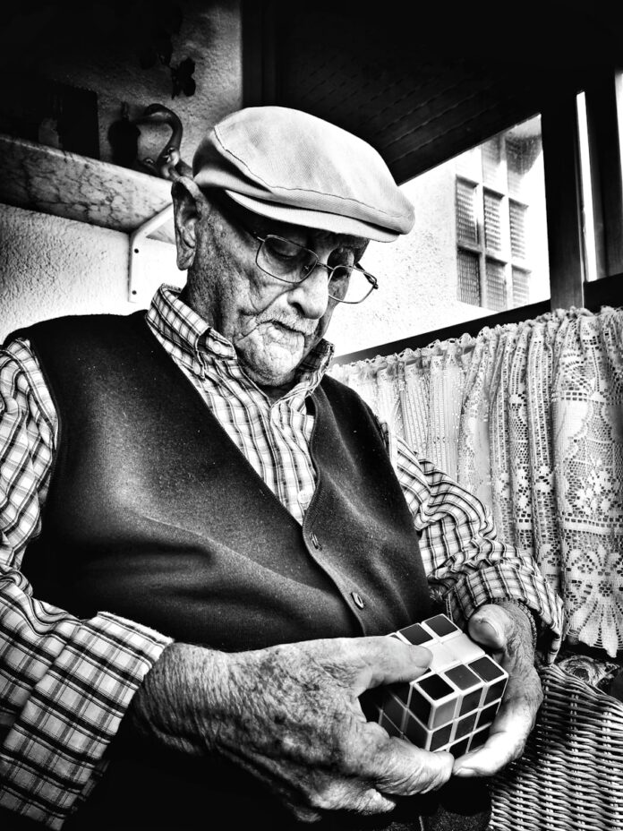Photo by Eva Gomez man holding Rubik's cube