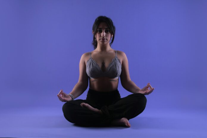 Photo by Brian Lawson a woman in a bra top sitting in a yoga pose