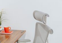 앉아있는 시간이 긴 직장인, 건강 지키는 생활습관으로 업무 효율 높인다 a gray office chair sitting next to a wooden table