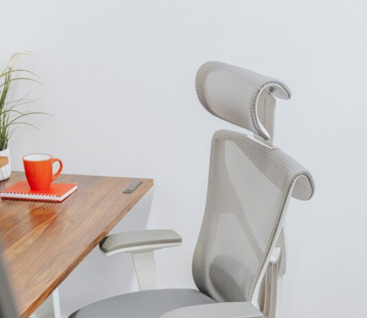 앉아있는 시간이 긴 직장인, 건강 지키는 생활습관으로 업무 효율 높인다 a gray office chair sitting next to a wooden table