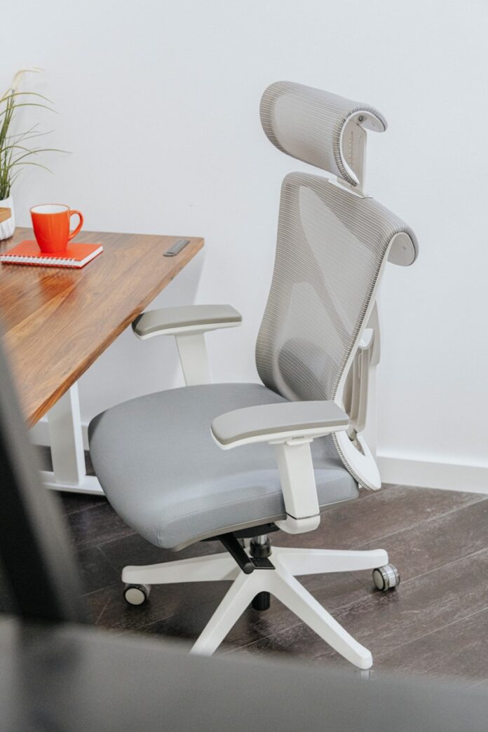 Photo by EFFYDESK a gray office chair sitting next to a wooden table
