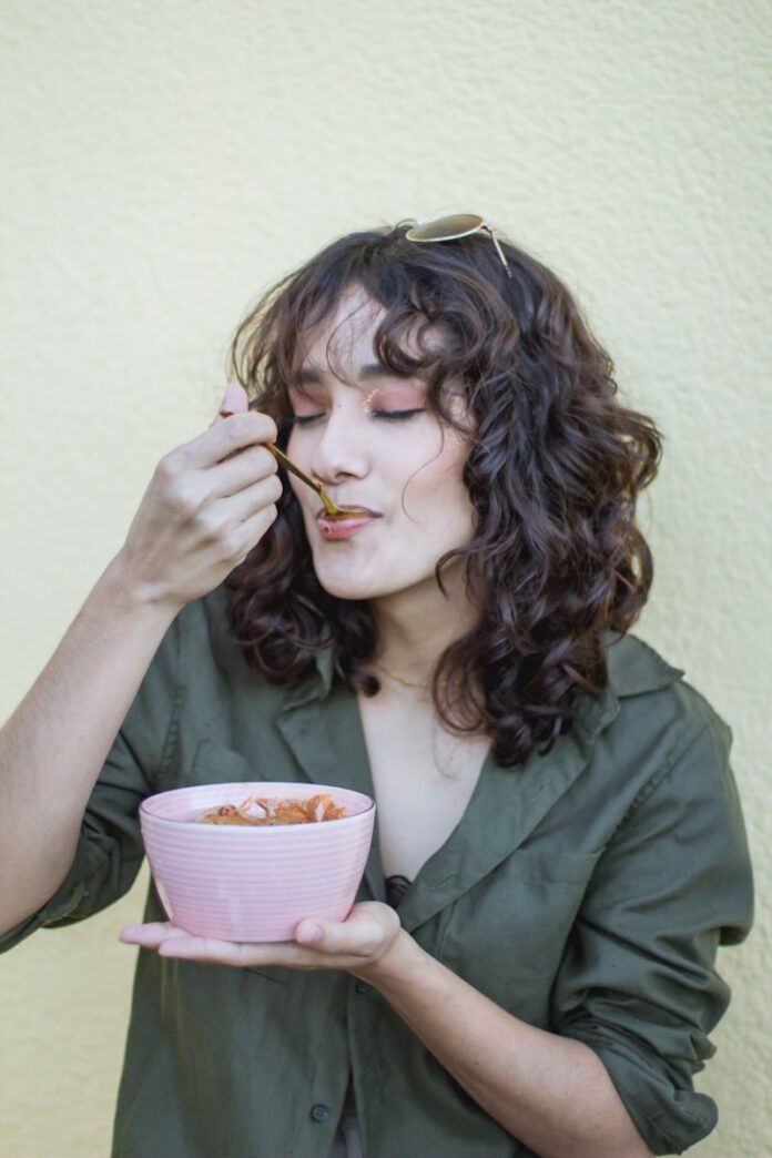 Photo by Diana Oramas a woman holding a pink bowl of food