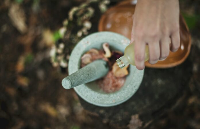 Photo by Katherine Hanlon high angle photo of person pouring liquid from bottle inside mortar and pestle