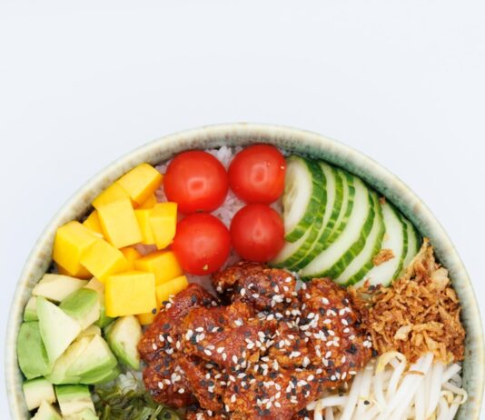 “맛있게, 건강하게! 요즘 뜨는 식단 트렌드와 실생활 실천법” A colorful poke bowl with fresh ingredients and chicken.