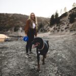 반려견과의 산책은 요가다: 서로의 보폭을 맞추는 치유의 시간 woman in black t-shirt holding blue and white ball