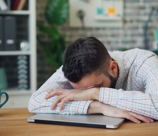 만성피로, 일상에서 벗어나기…작은 변화가 만드는 큰 힘 a man sitting at a desk with his head in his hands