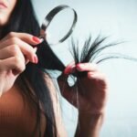 머릿결도 건강해야 아름답다…일상 속 실천하는 ‘두피·모발 관리법’ 주목 Woman examining split ends of hair with magnifying glass