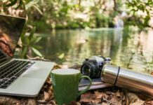 “잘 자야 내일이 가볍다”…당신의 수면 습관, 최신 트렌드로 바꿔볼 때 Laptop, camera, and mug by a forest stream