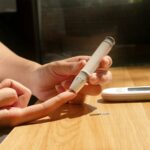 혈당 스파이크 예방 가이드: 우리의 식탁이 건강을 지키는 방법 a person sitting at a table with a cell phone